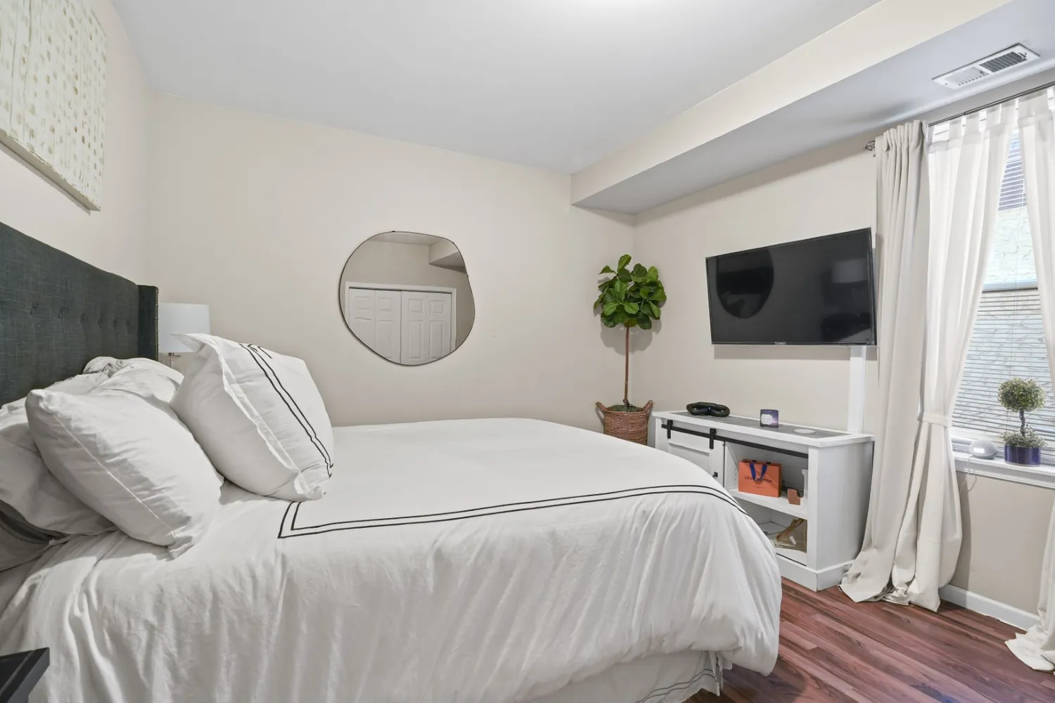 a living room with furniture flat screen tv and a large window