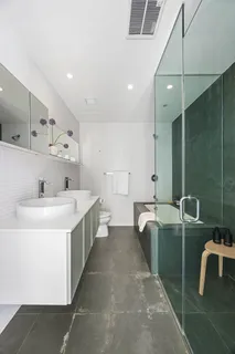 a large white kitchen with a sink a toilet and a mirror
