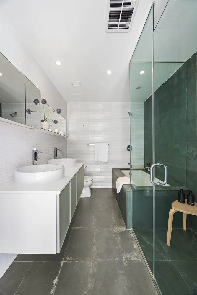 a large white kitchen with a sink a toilet and a mirror