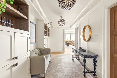 a living room with furniture a large window and a chandelier