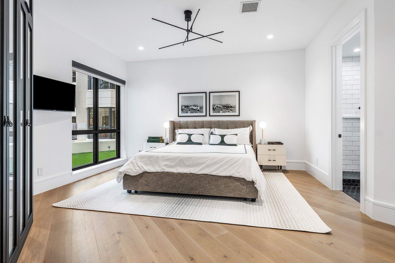 a spacious bedroom with a bed and a flat screen tv