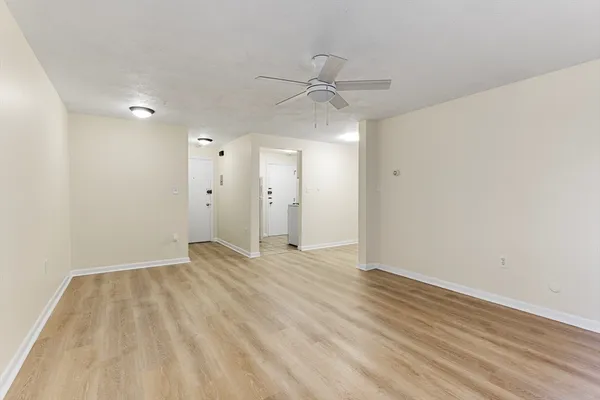 an empty room with wooden floor and windows