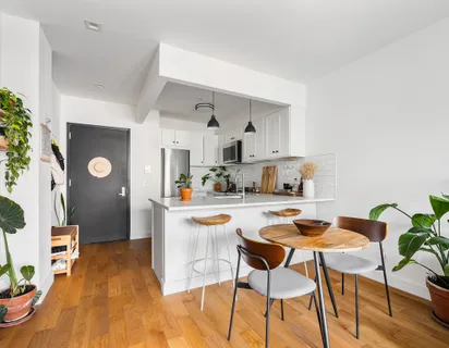 a dining room with stainless steel appliances kitchen island granite countertop a dining table chairs and chandelier