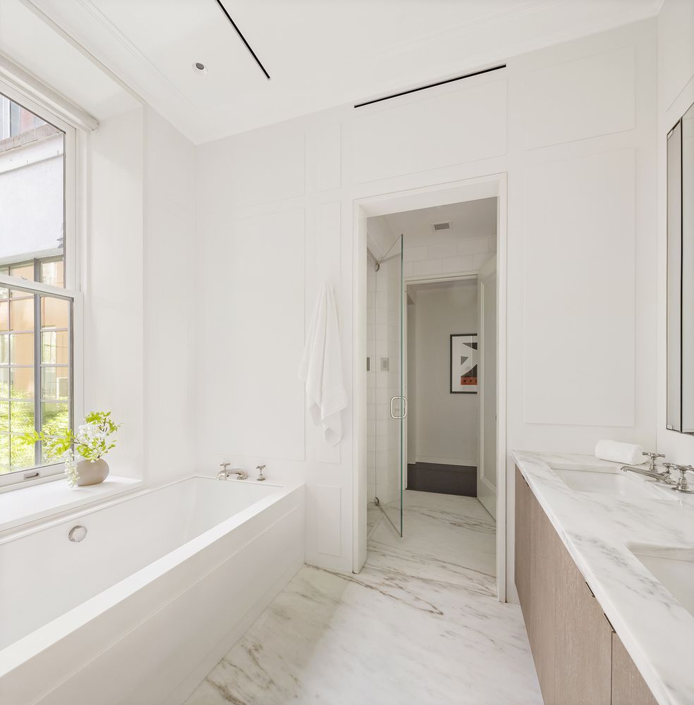 a spacious bathroom with a tub sink and mirror