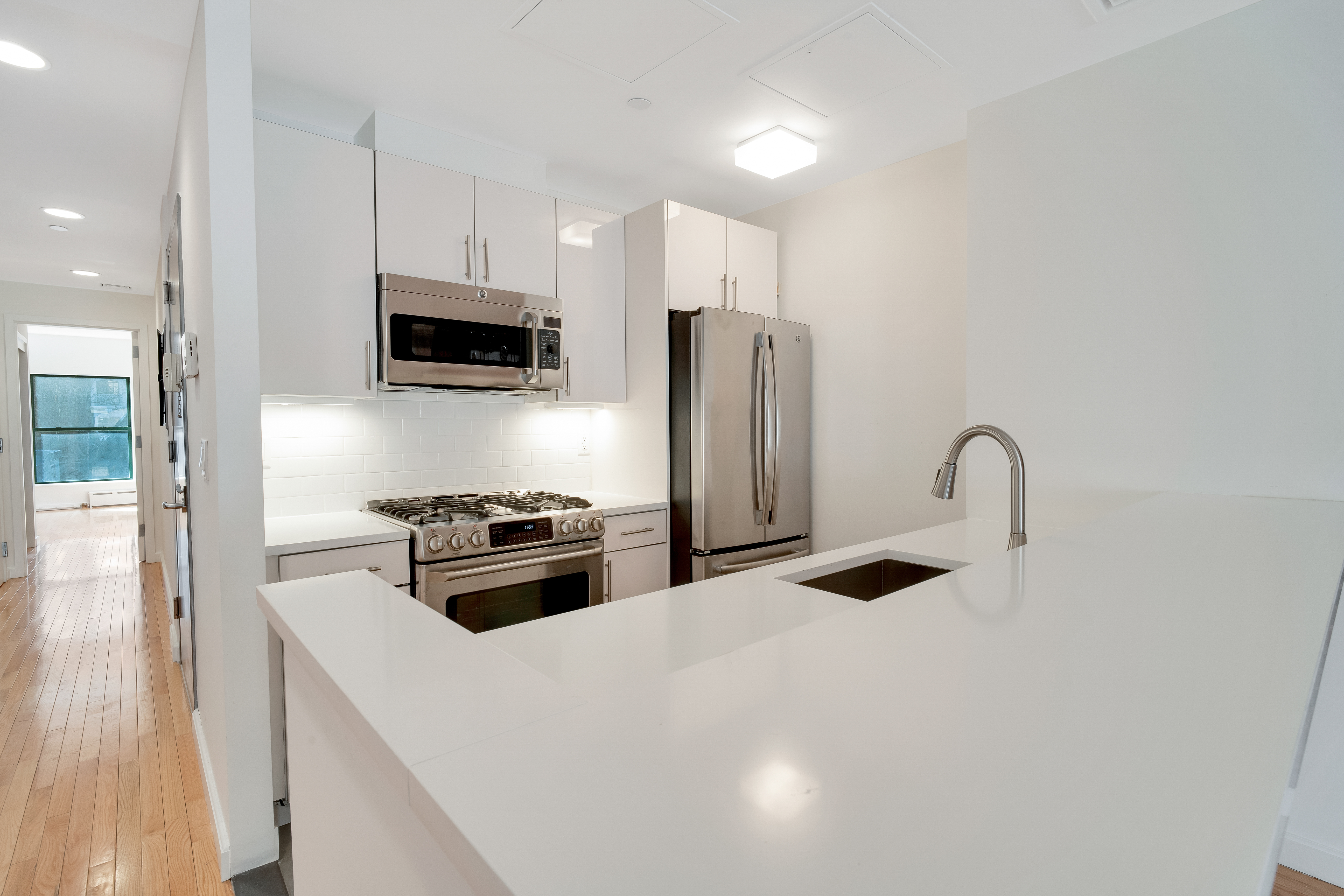 228 West 75th Street, Unit 4 Manhattan, NY 10023 - Photo 4 of 13 a kitchen with stainless steel appliances a refrigerator a stove a sink and a white cabinets