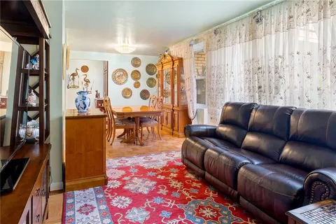 a living room with furniture a rug and a painting on the wall