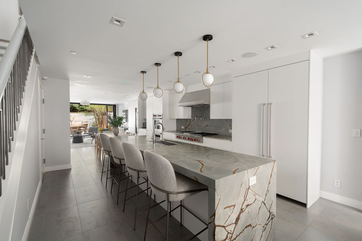 520 East 89th Street Manhattan, NY 10128 - Photo 10 of 40 a kitchen with stainless steel appliances kitchen island granite countertop a table chairs and a refrigerator