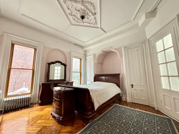 a bedroom with a bed lamp closet and large window