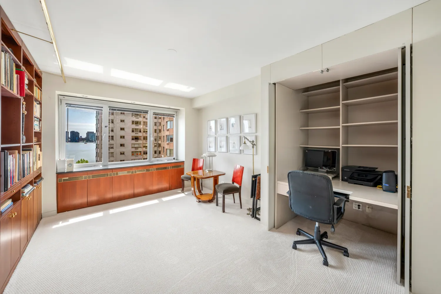 a view of a workspace with furniture and a window
