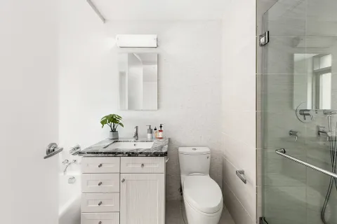 a bathroom with a granite countertop toilet sink and mirror