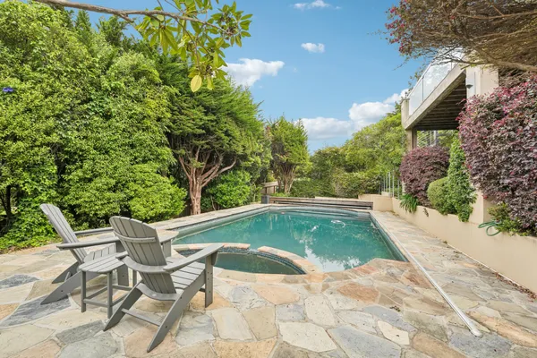 a view of backyard with swimming pool and seating space