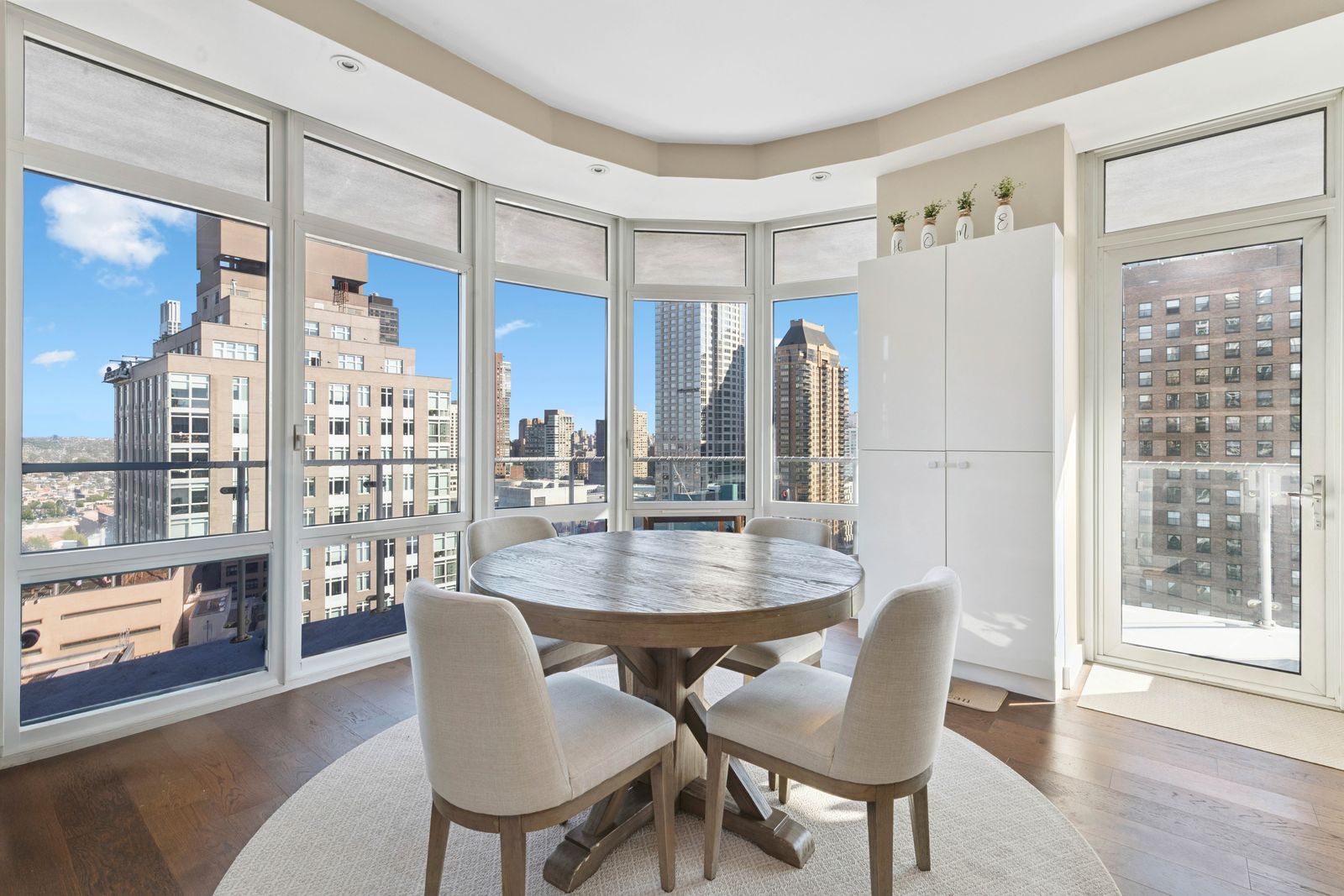 555 West 59th Street, Unit 28D Manhattan, NY 10019 - Photo 2 of 19 a dining room with furniture a chandelier and wooden floor