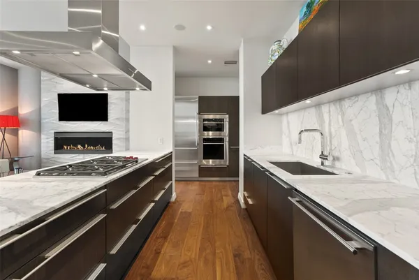 a large kitchen with stainless steel appliances granite countertop a stove and a sink