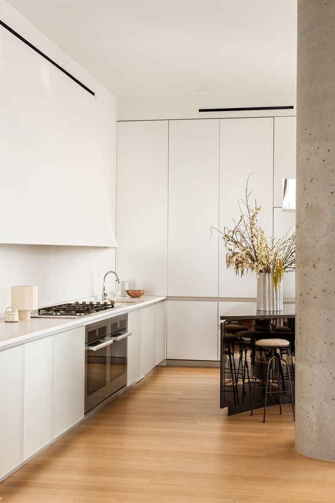a kitchen with stainless steel appliances white cabinets and wooden floor