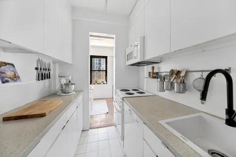 a kitchen with a sink a stove and cabinets