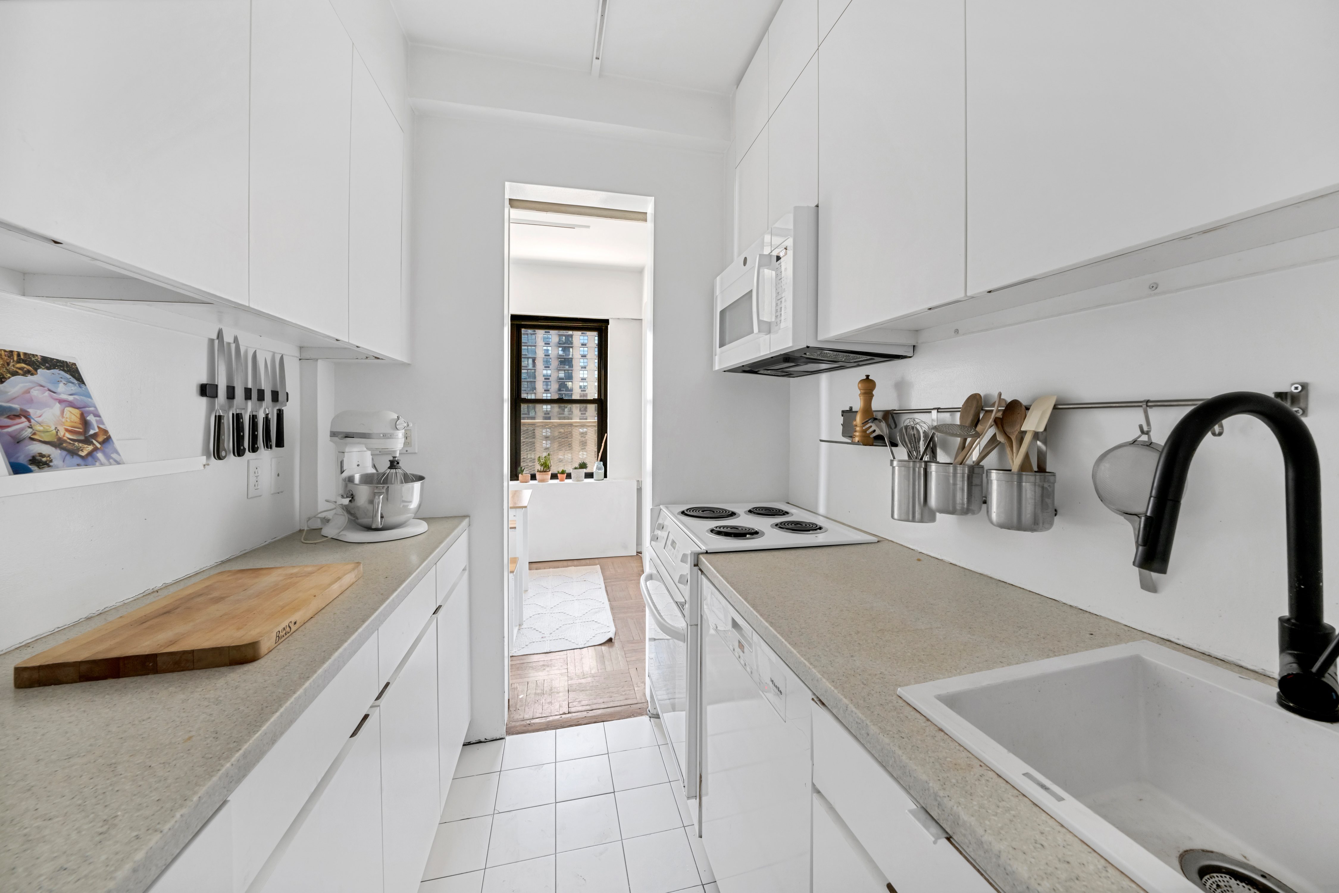 2 Tudor City Place, Unit 15AS Manhattan, NY 10017 - Photo 6 of 17 a kitchen with a sink a stove and cabinets