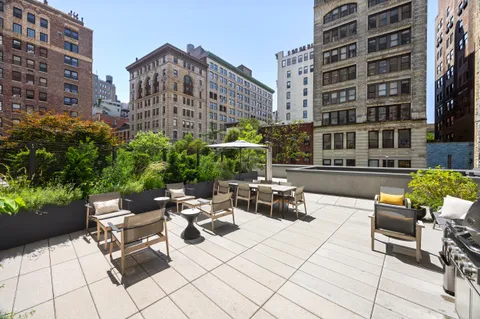 a view of a patio with a table and chairs and potted plants