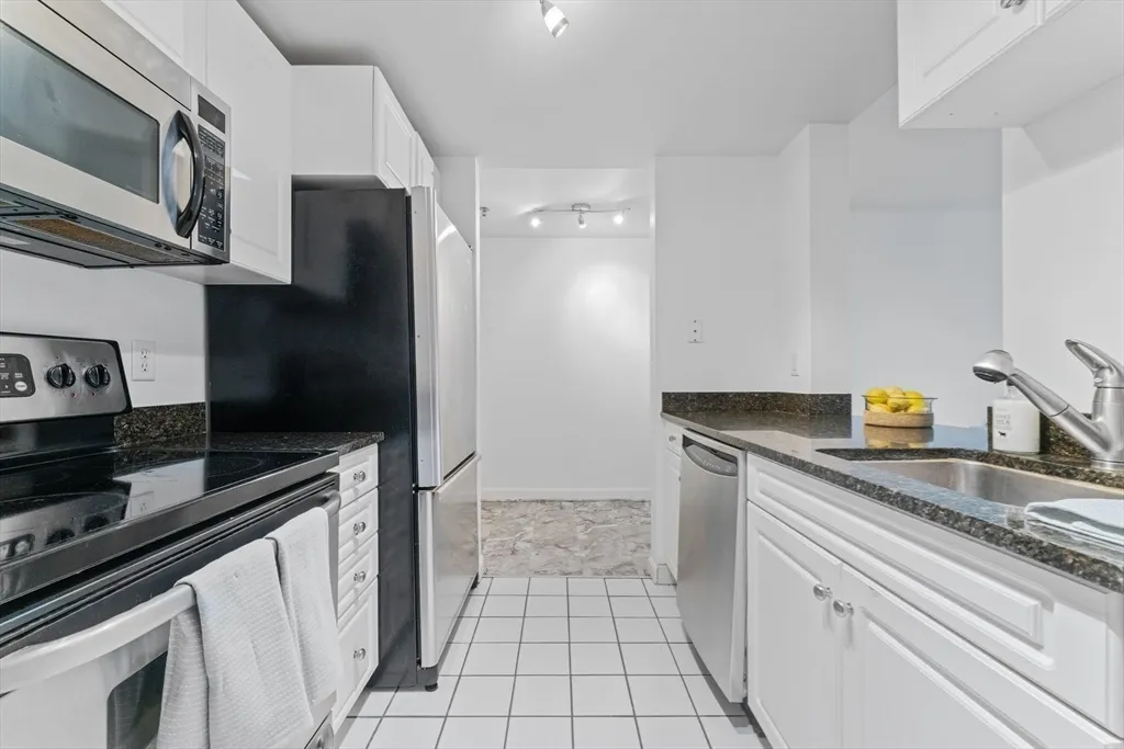 a kitchen with stainless steel appliances granite countertop a refrigerator and a stove