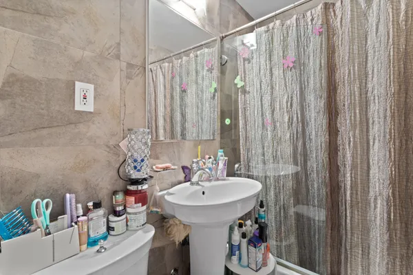 a bathroom with a sink a toilet and shower curtain