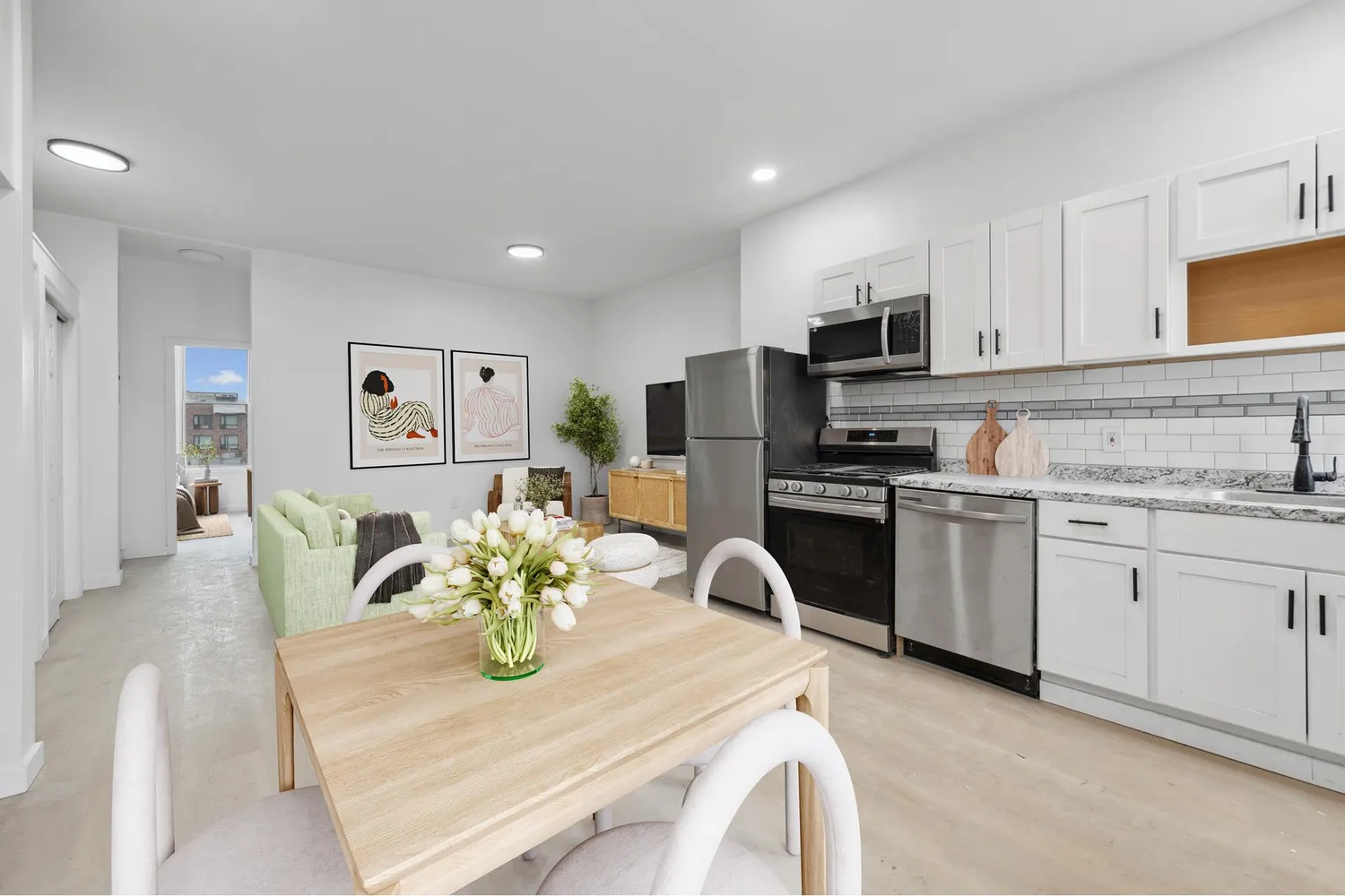 a kitchen with stainless steel appliances granite countertop a refrigerator a stove top oven a sink a dining table and chairs