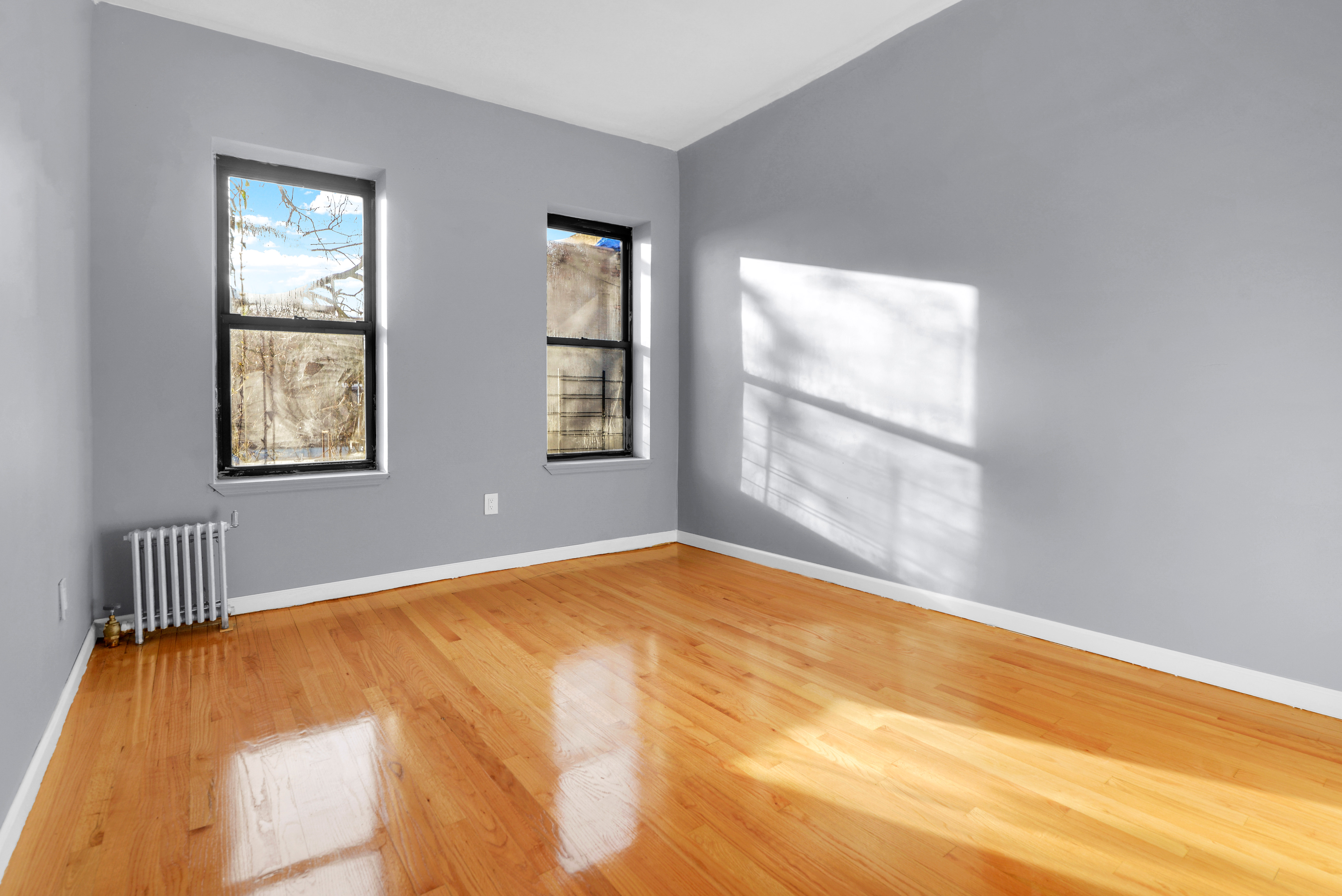 2302 Bedford Avenue, Unit 3 Brooklyn, NY 11226 - Photo 7 of 25 a view of an empty room with wooden floor and a window