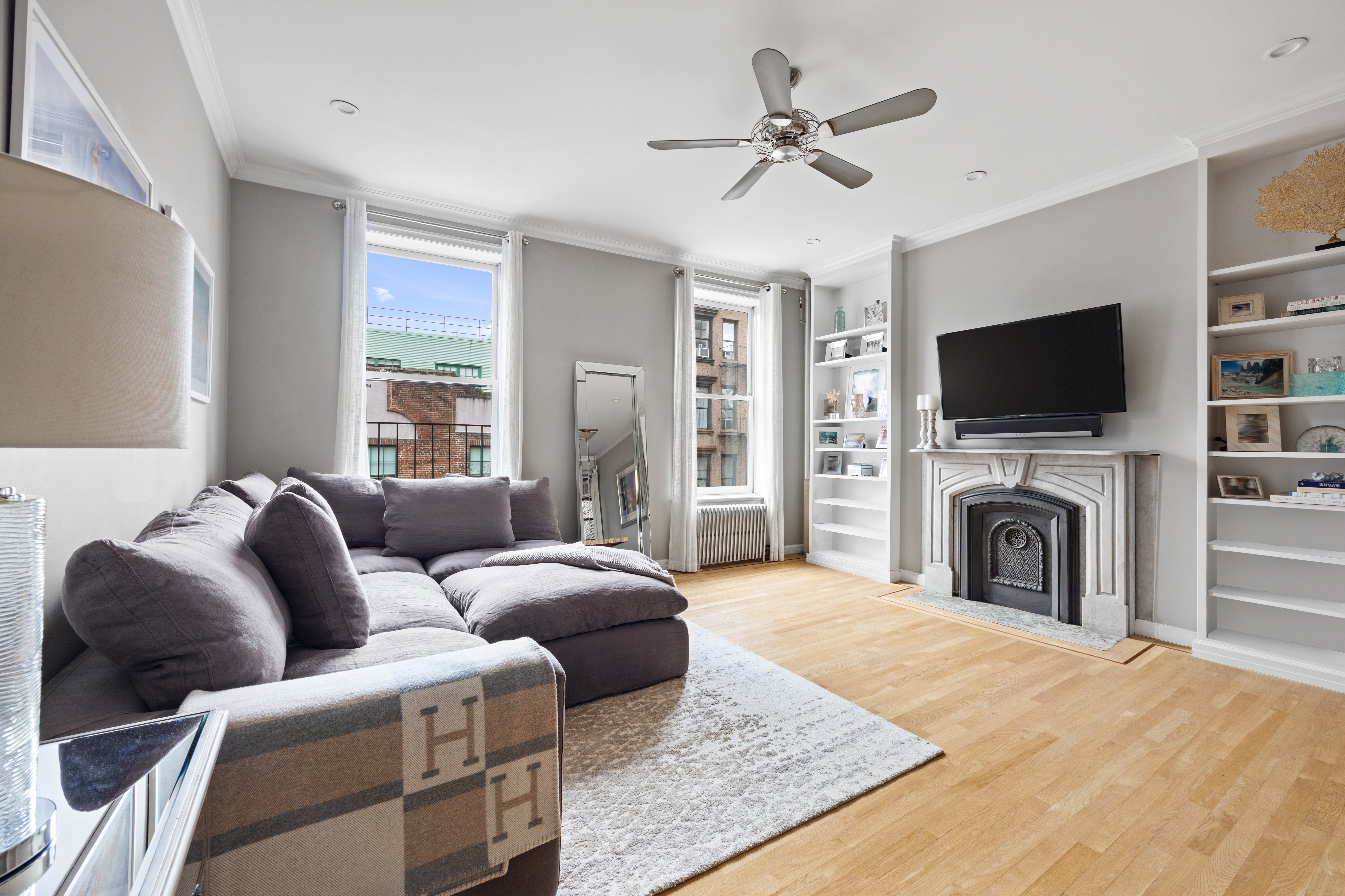 791 Greenwich Street, Unit 6 Manhattan, NY 10014 - Photo 2 of 7 a living room with furniture a fireplace and a flat screen tv