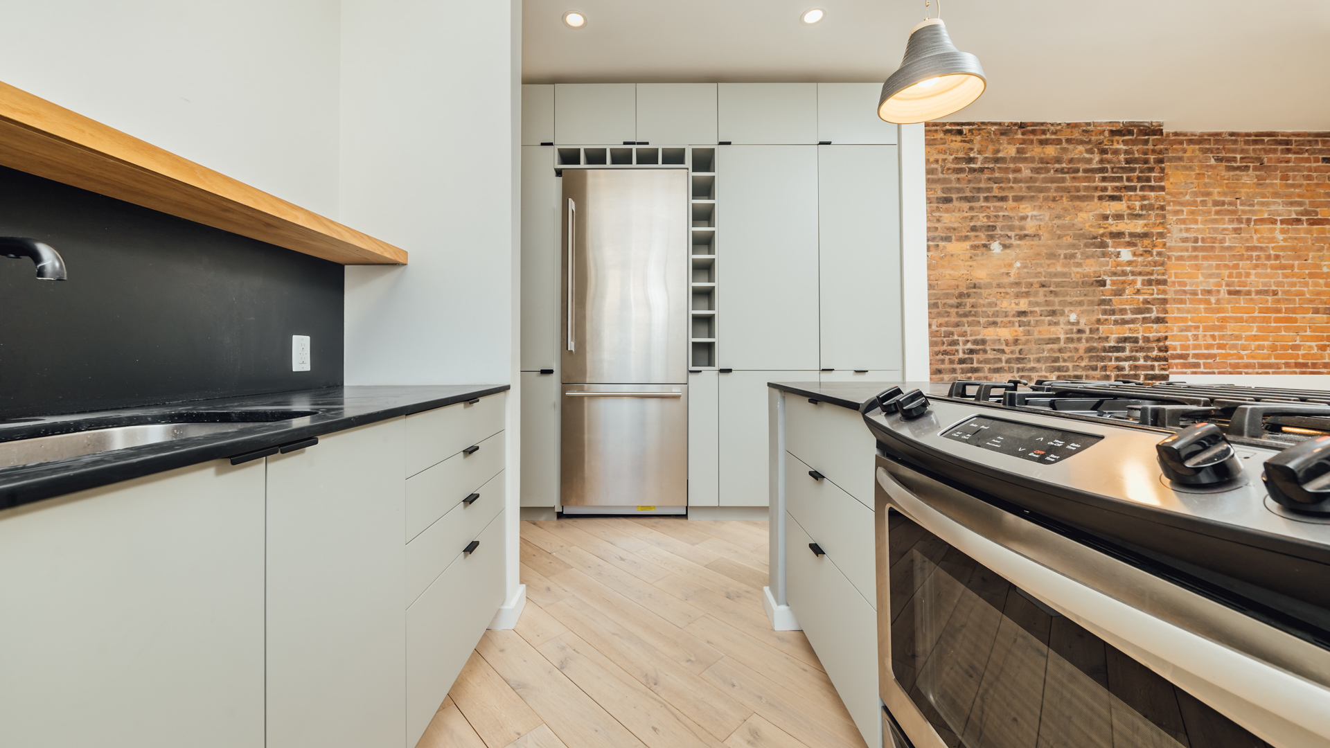 880 Woodward Avenue, Unit 2 Queens, NY 11385 - Photo 7 of 18 a kitchen with granite countertop a sink stove and refrigerator