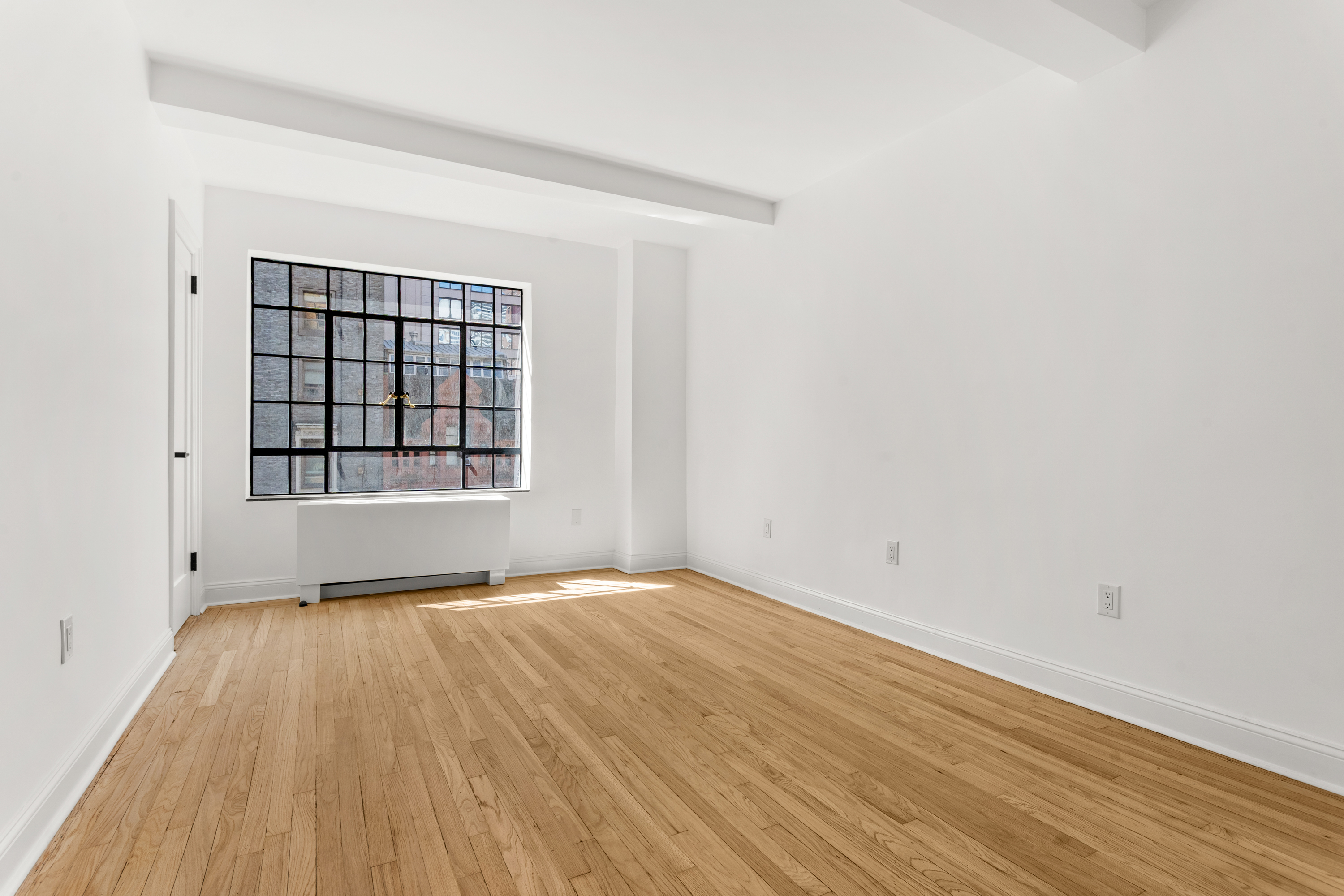 10 Park Avenue, Unit 6A Manhattan, NY 10016 - Photo 10 of 14 an empty room with wooden floor and windows