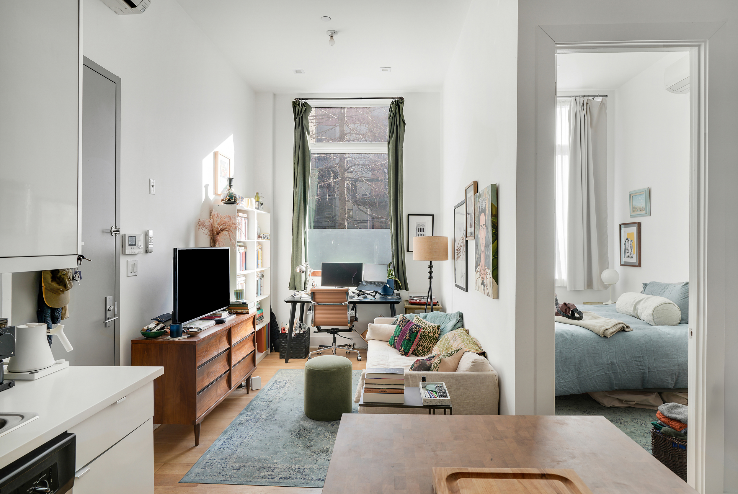 a living room with furniture a flat screen tv and a view of kitchen