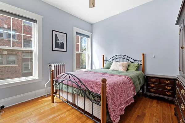 a bedroom with a bed a window and dresser