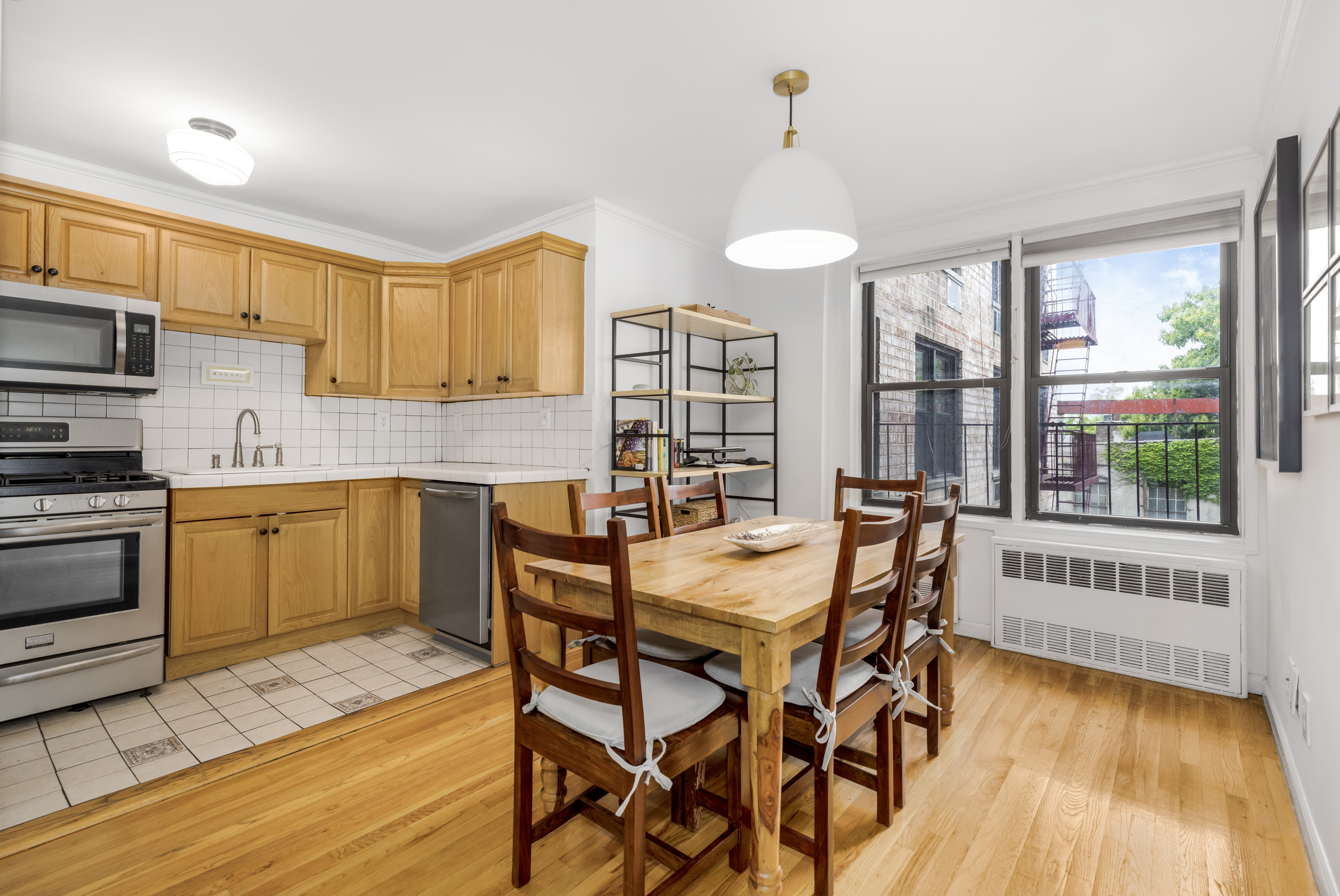 165 Christopher Street, Unit 3A Manhattan, NY 10014 - Photo 4 of 8 a kitchen with a table chairs sink and cabinets