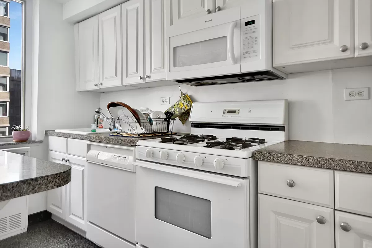 a kitchen with granite countertop white cabinets and white appliances