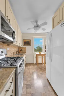 a kitchen with stainless steel appliances granite countertop a stove a sink and a refrigerator