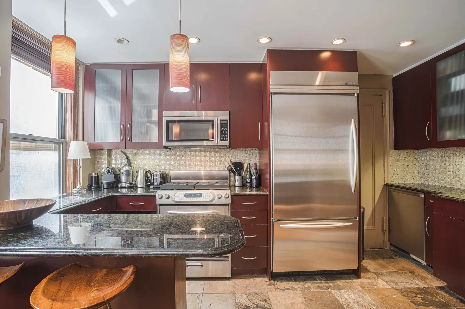 a kitchen with kitchen island granite countertop a sink appliances and cabinets