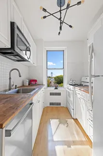 a large white kitchen with stainless steel appliances granite countertop a sink and cabinets
