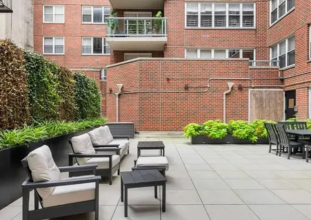 a backyard of a house with a chairs and table