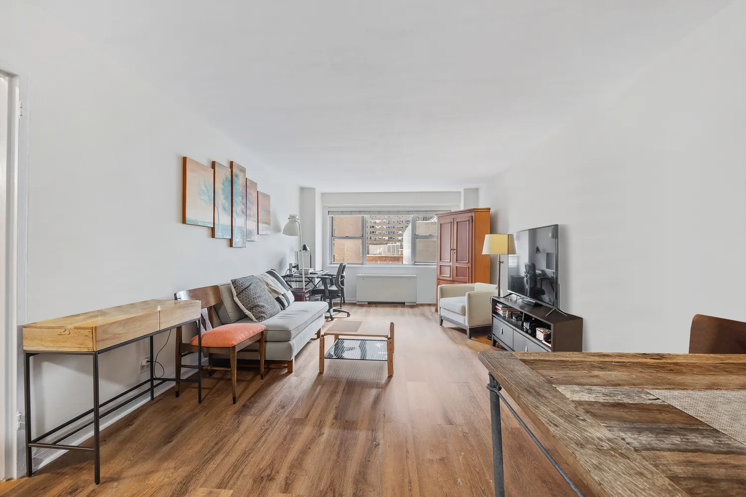a living room with furniture and a wooden floor