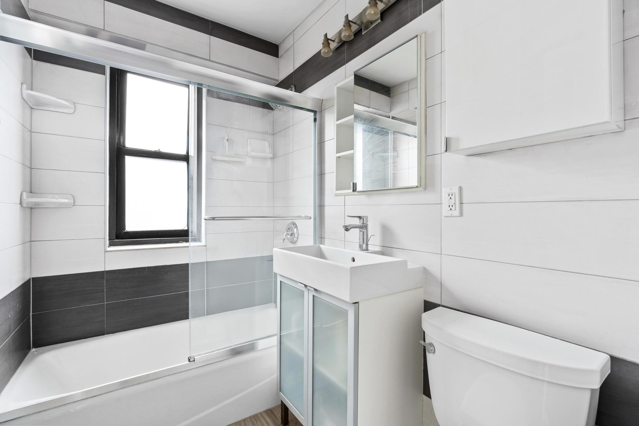 266 East Broadway, Unit 1304B Manhattan, NY 10002 - Photo 8 of 8 a bathroom with a sink a toilet and shower