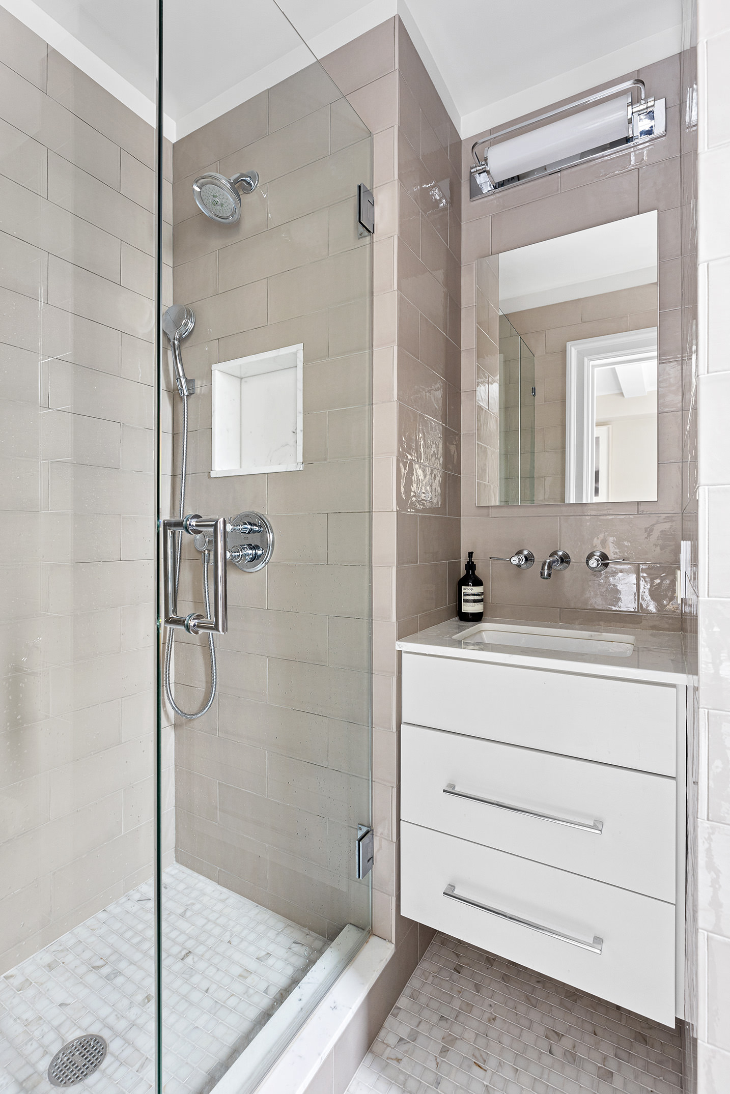 930 5th Avenue, Unit 11D Manhattan, NY 10021 - Photo 9 of 11 a bathroom with a shower sink and mirror