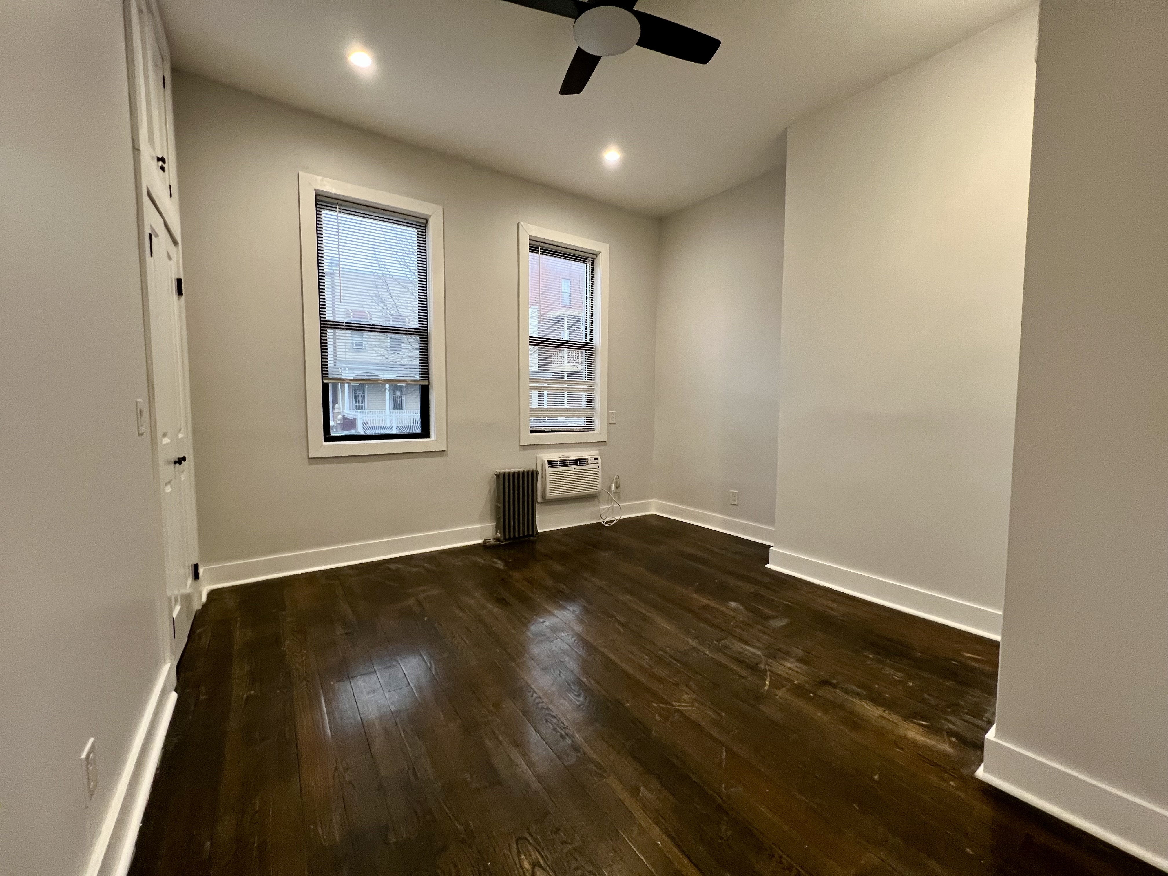 20 Suydam Street, Unit 1 Brooklyn, NY 11221 - Photo 7 of 10 an empty room with wooden floor cabinet and windows