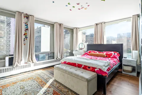 a bedroom with a bed and a large window