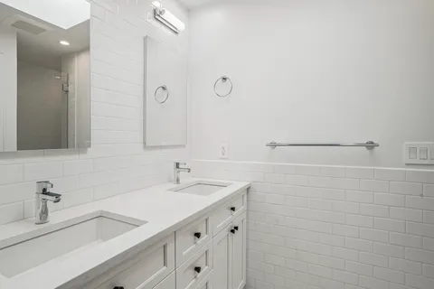 a bathroom with a sink double vanity and a shower