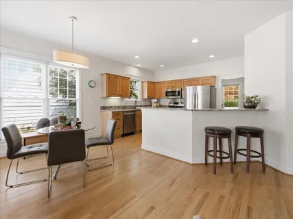 a living room with furniture a kitchen view and a fireplace