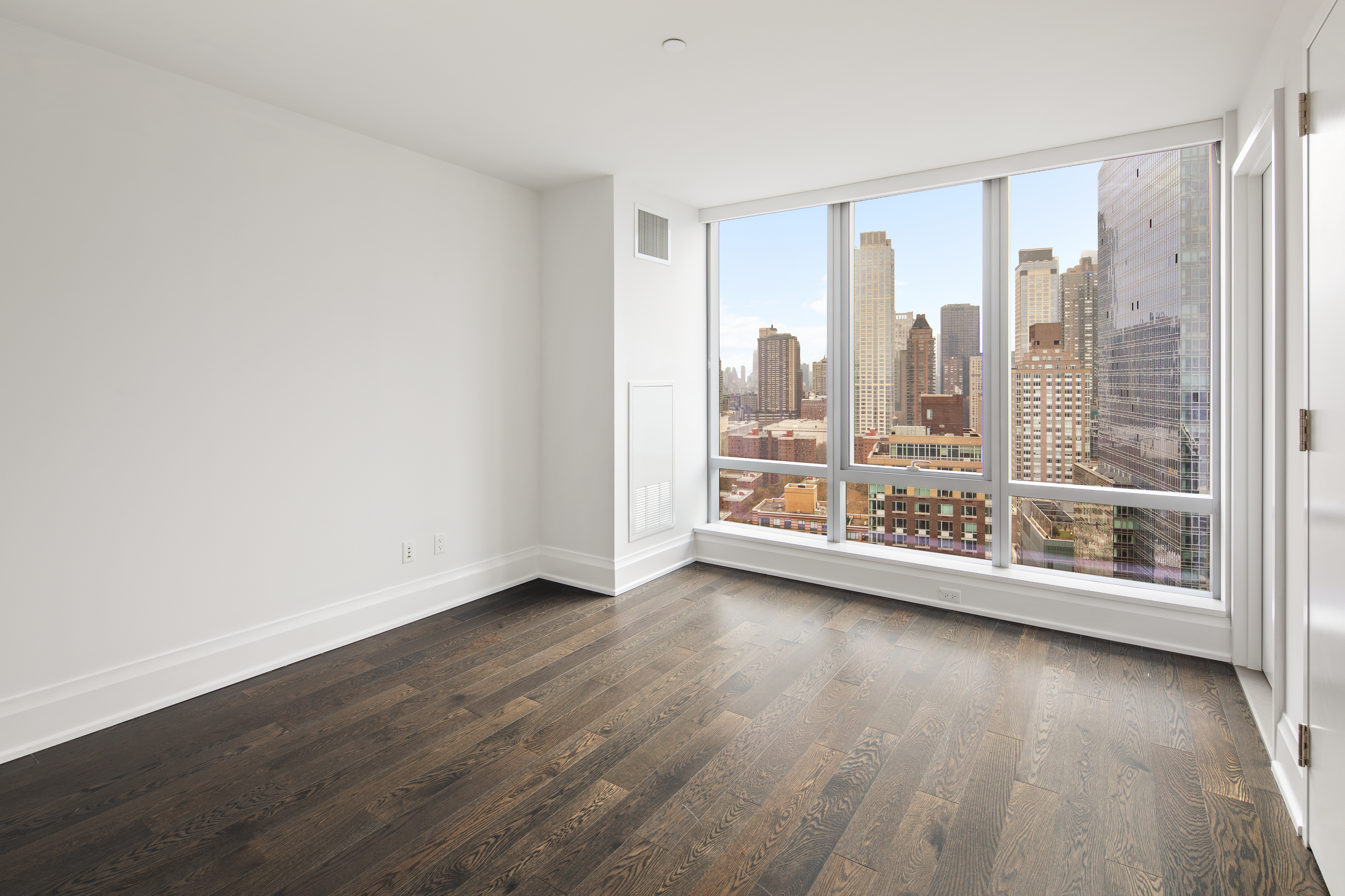 50 Riverside Boulevard, Unit 30B Manhattan, NY 10069 - Photo 11 of 14 an empty room with wooden floor and windows