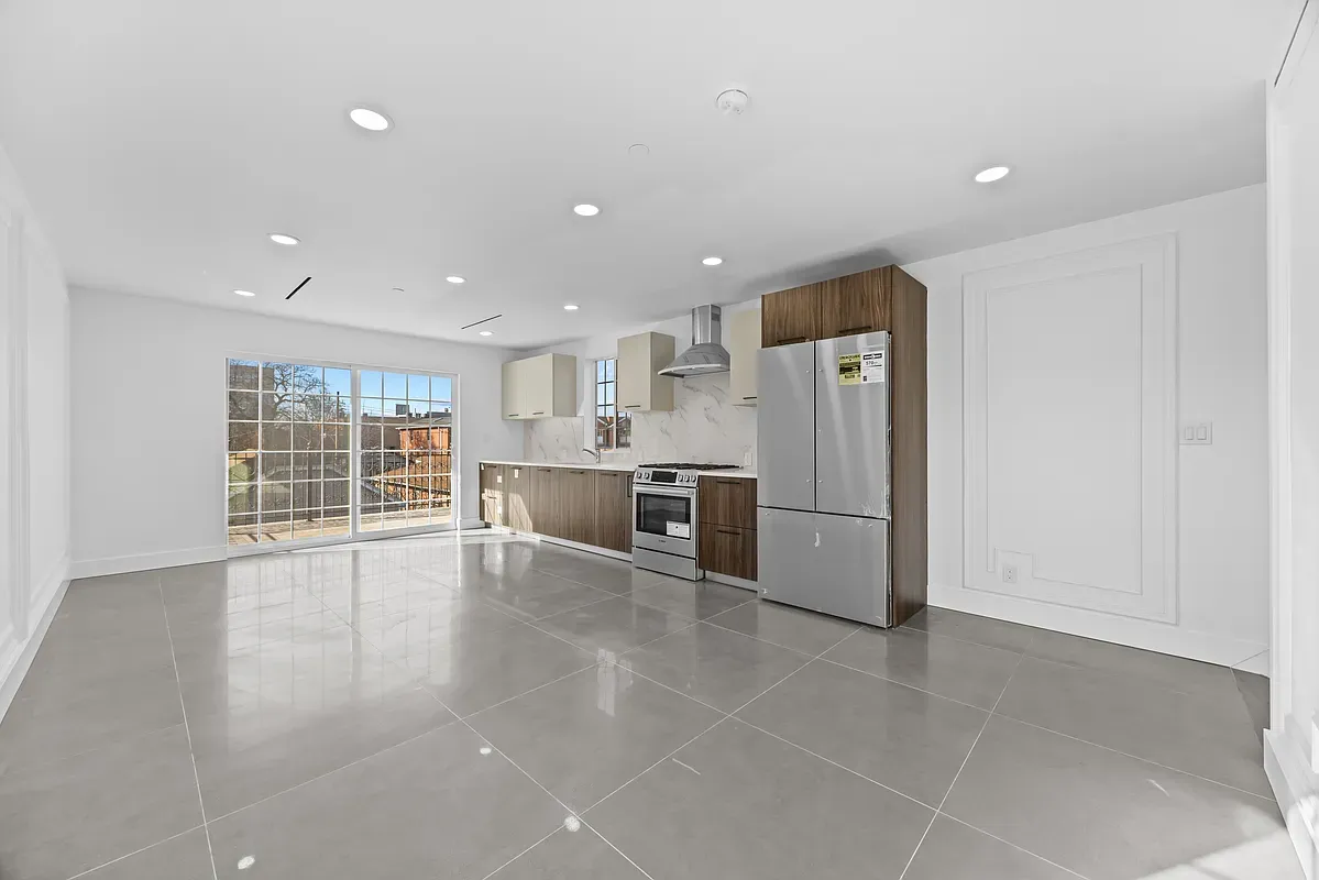 a view of a kitchen with refrigerator and window