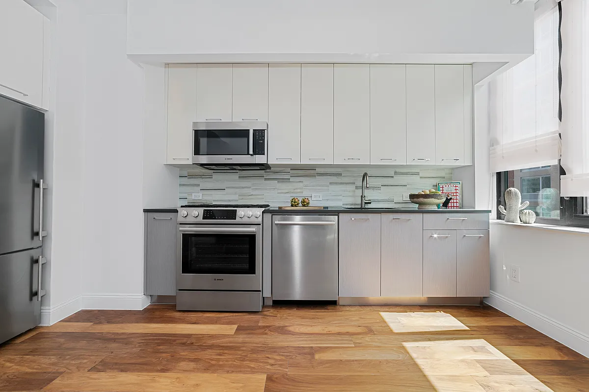 42-14 Crescent Street, Unit 9D Queens, NY 11101 - Photo 4 of 6 a kitchen with granite countertop a stove and a sink