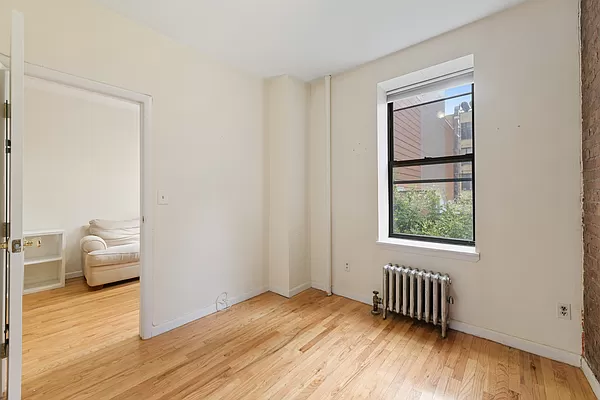 309 East 95th Street, Unit 17 Manhattan, NY 10128 - Photo 3 of 4 a view of empty room with wooden floor and fan