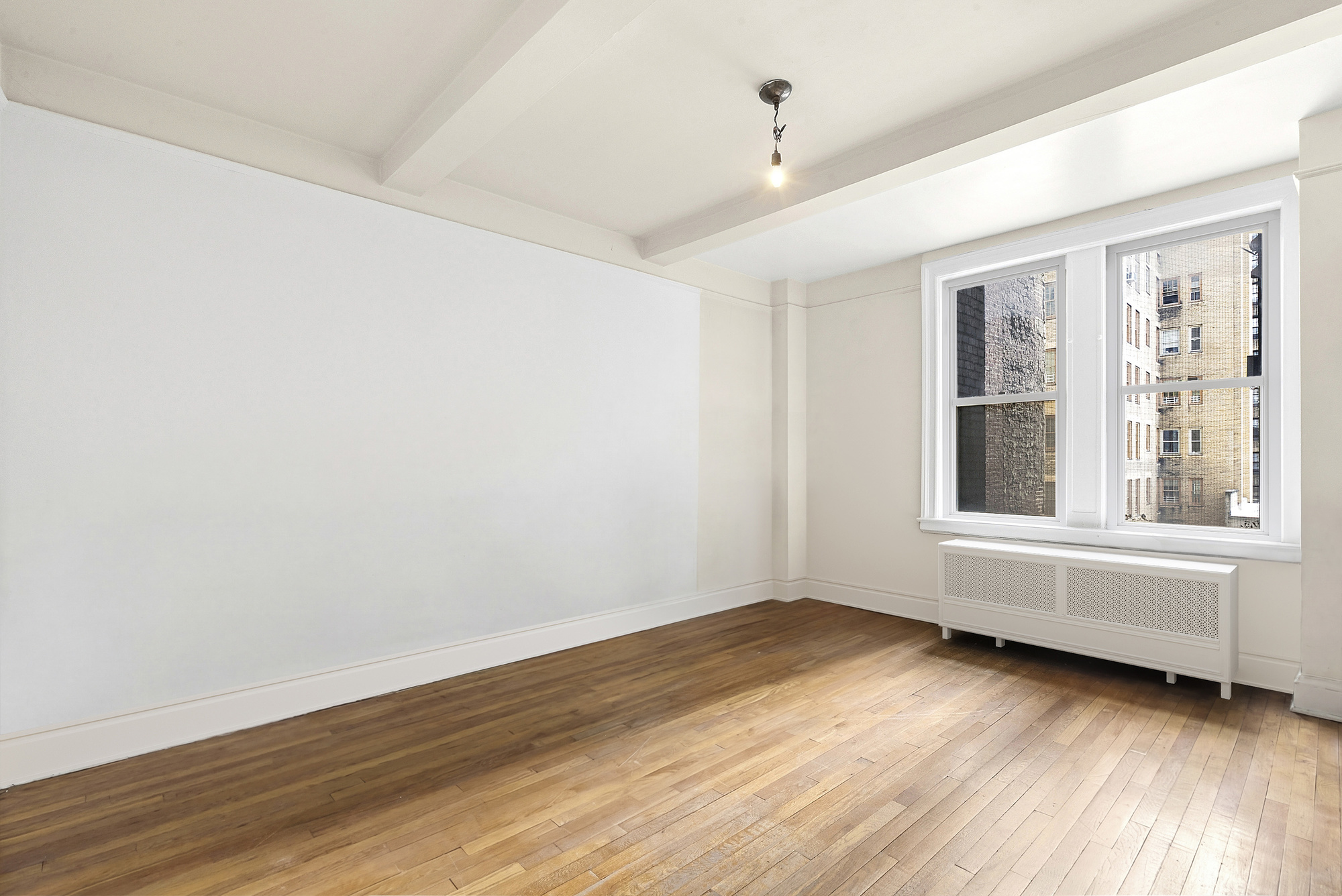 12 West 96th Street, Unit 9A Manhattan, NY 10025 - Photo 11 of 14 an empty room with wooden floor and windows