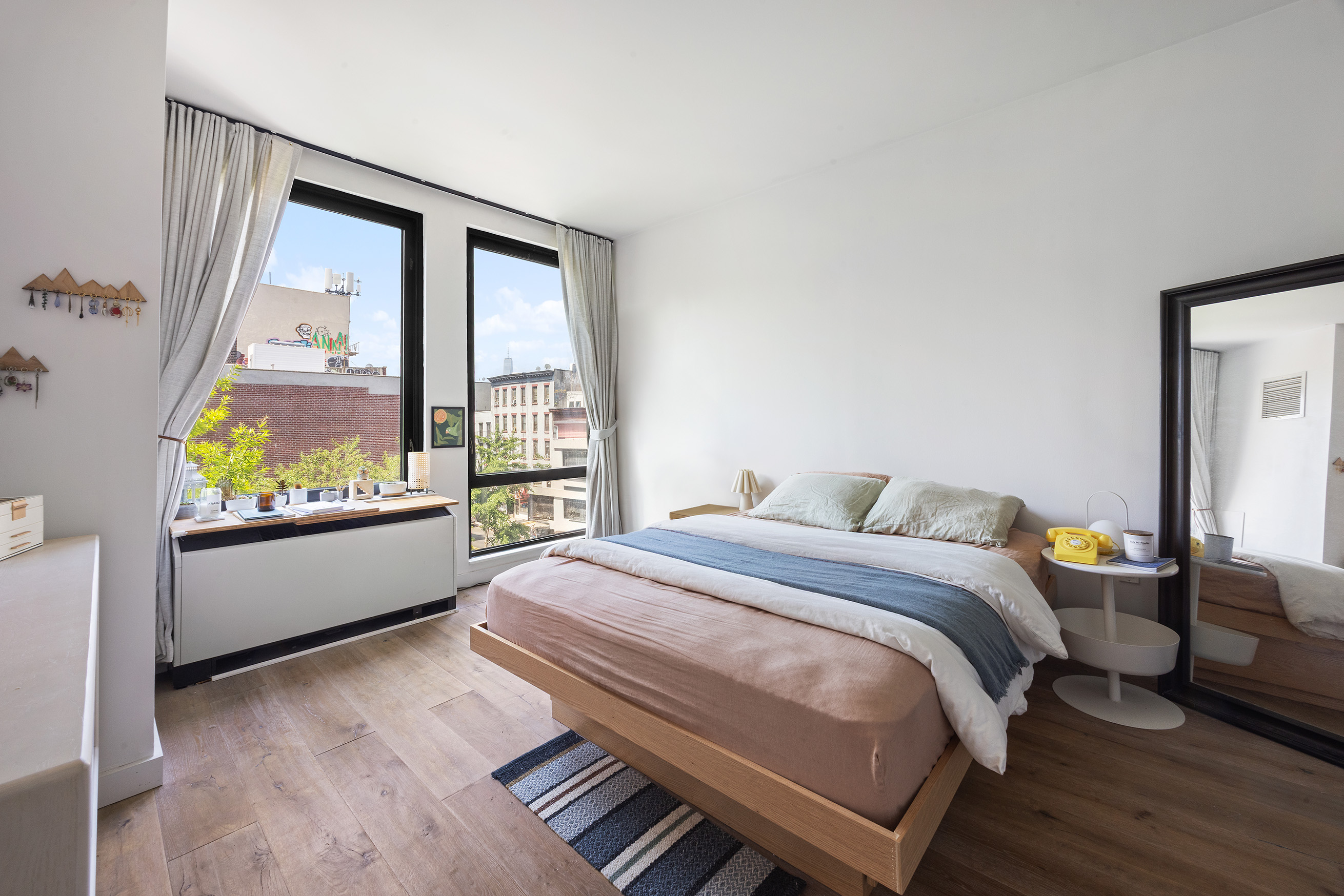 215 Avenue B, Unit 4A Manhattan, NY 10009 - Photo 6 of 13 a bed sitting in a bedroom next to a window