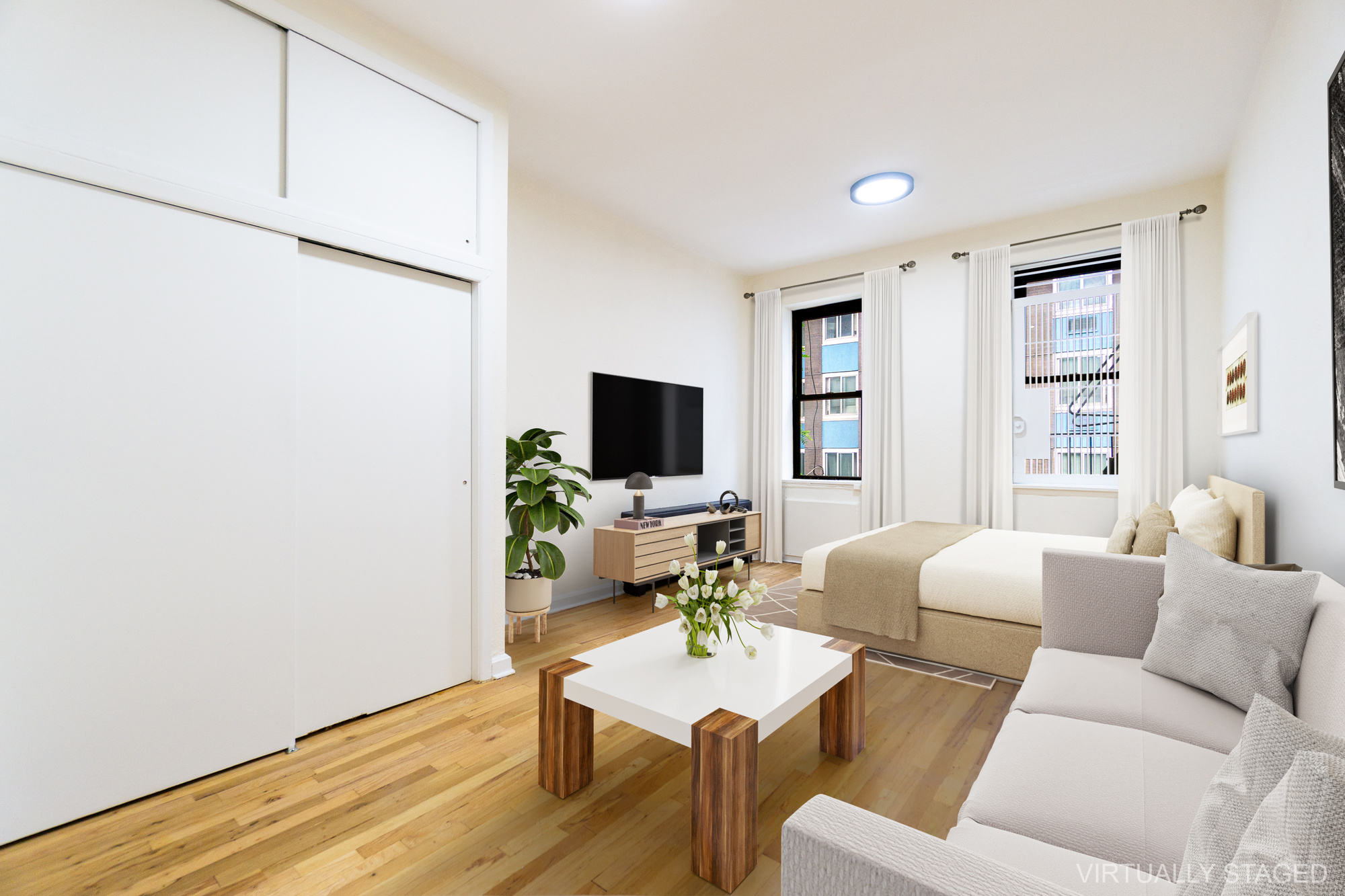 a living room with furniture a flat screen tv and a window